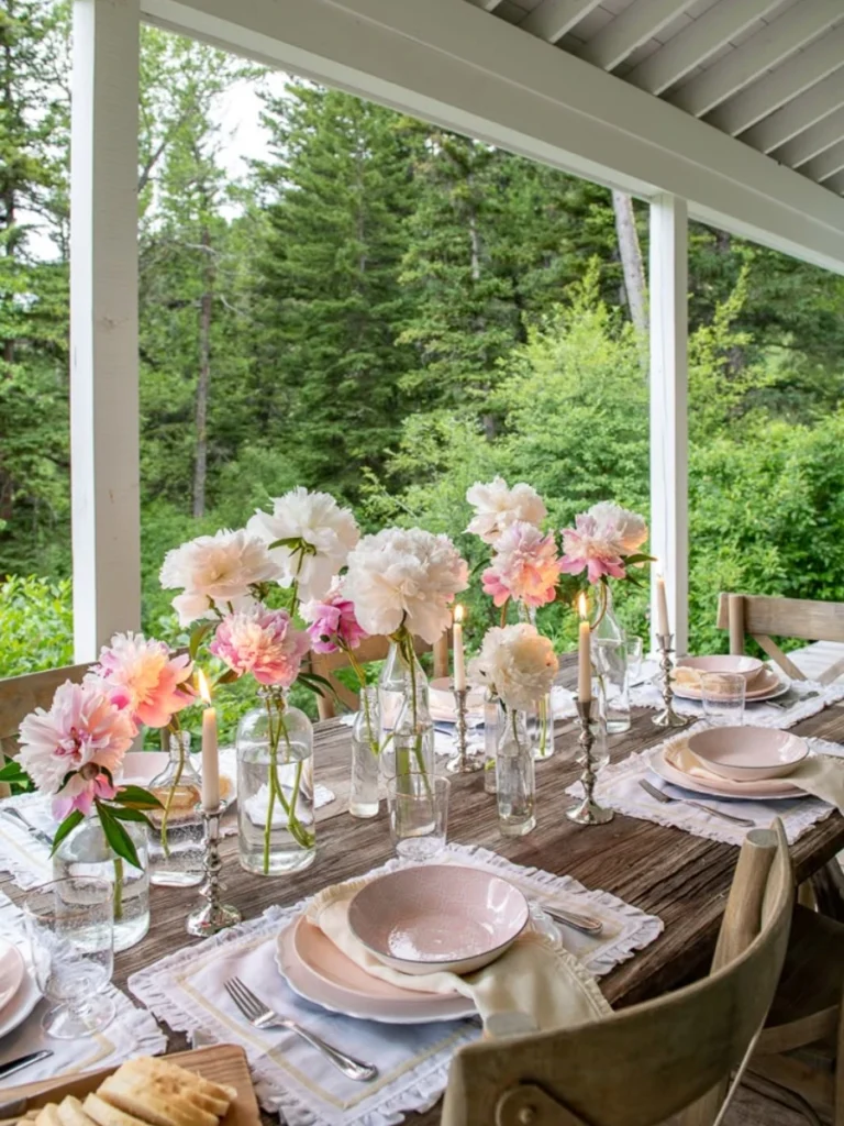 Arrange Five Clear Glass Bud Bottles Holding Single Pink Dahlias Along a Textured Linen Runner
