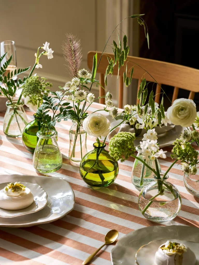 Distributed Clear Glass Bud Vases with Single Clementine Stems